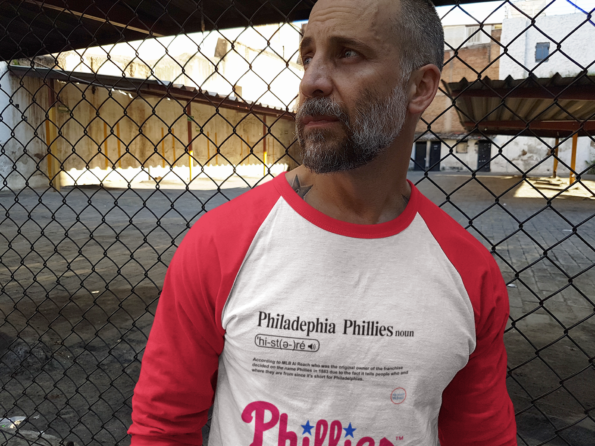middle-aged-white-man-staring-away-and-leaning-against-a-rusty-fence-raglan-tee-mockup-b12613
